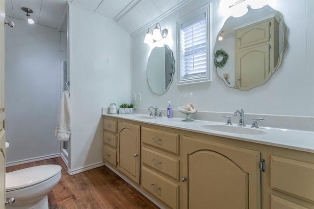 bathroom with hardwood / wood-style flooring, vanity, toilet, and vaulted ceiling