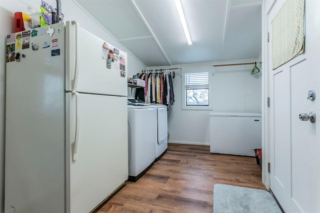 washroom with washing machine and dryer and hardwood / wood-style floors