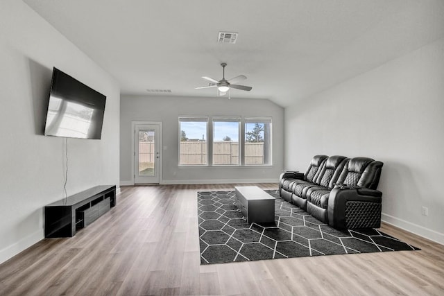 living room with lofted ceiling, ceiling fan, and dark wood-type flooring