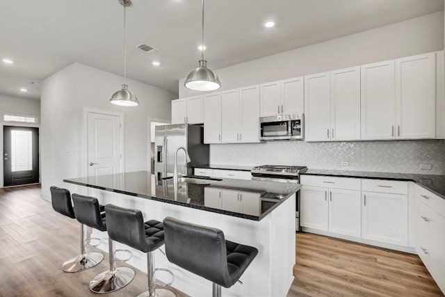 kitchen featuring a kitchen island with sink, light hardwood / wood-style flooring, and stainless steel appliances