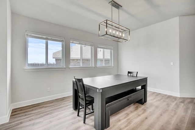 dining space featuring light hardwood / wood-style floors and a notable chandelier