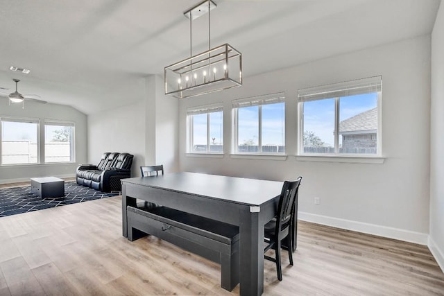 dining area with a healthy amount of sunlight, light hardwood / wood-style floors, and ceiling fan with notable chandelier