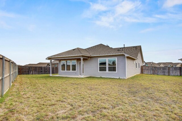 back of house with a yard and a patio