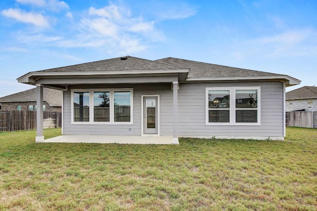 rear view of property featuring a lawn and a patio