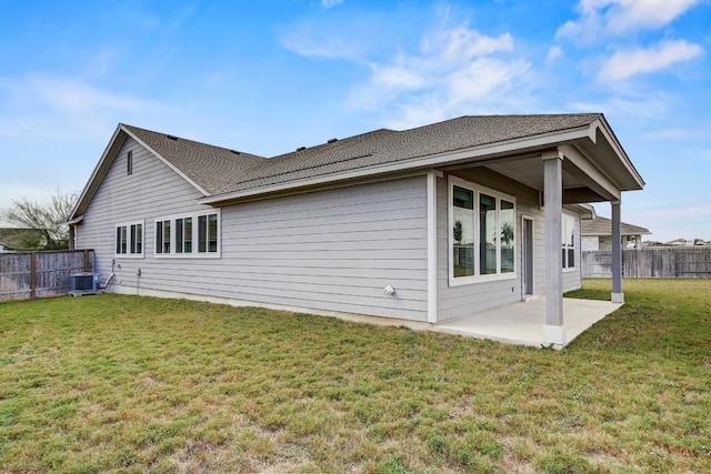 rear view of house featuring a yard, cooling unit, and a patio area