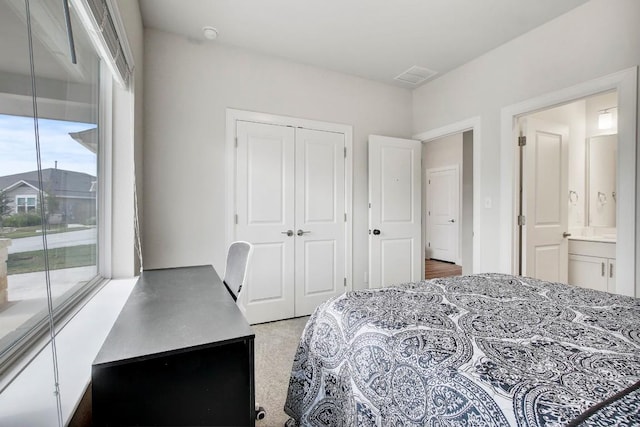 carpeted bedroom with ensuite bath, access to outside, and a closet