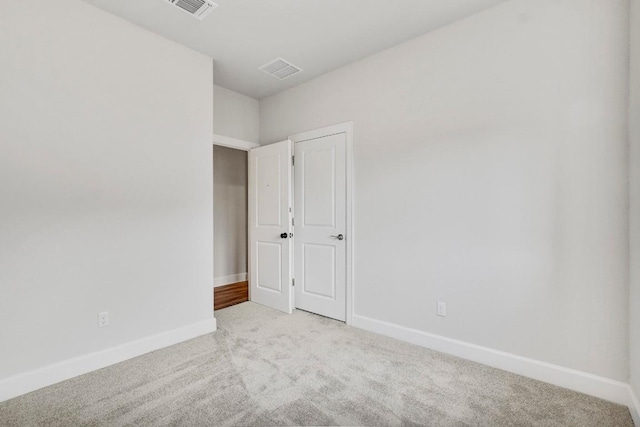 unfurnished room featuring light carpet