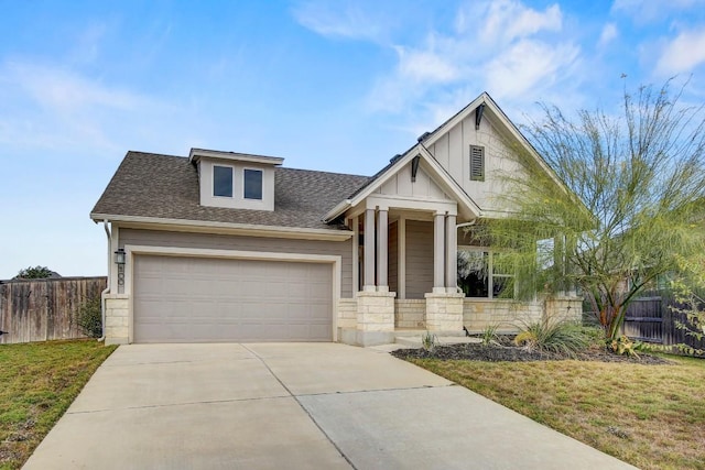 craftsman-style home featuring covered porch, a garage, and a front yard