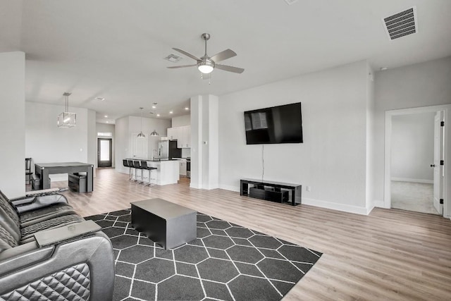 living room featuring wood-type flooring and ceiling fan