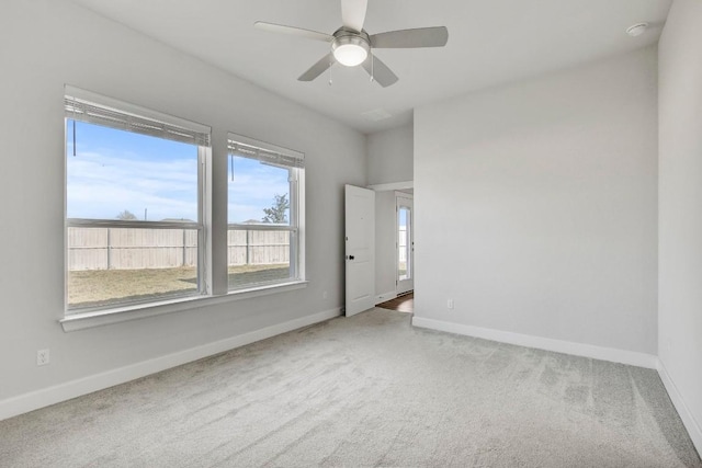 carpeted empty room featuring ceiling fan and a healthy amount of sunlight