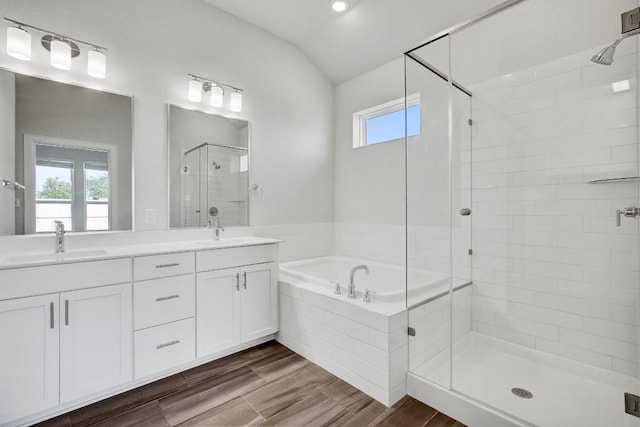 bathroom with plus walk in shower, hardwood / wood-style floors, vaulted ceiling, and plenty of natural light