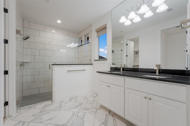 bathroom featuring tiled shower and vanity