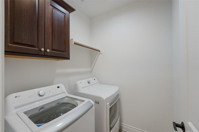 washroom featuring washing machine and dryer and cabinets