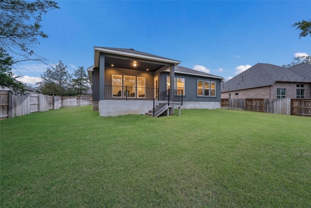 rear view of property featuring a lawn