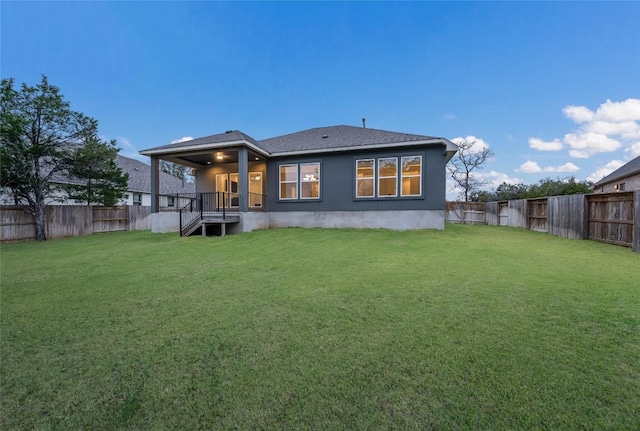 rear view of house featuring a yard