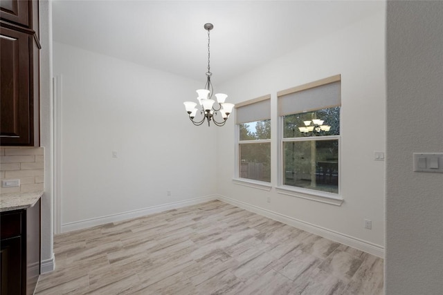 unfurnished dining area featuring light hardwood / wood-style floors and a notable chandelier