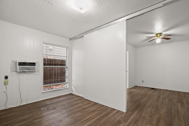 empty room featuring a textured ceiling and dark hardwood / wood-style floors