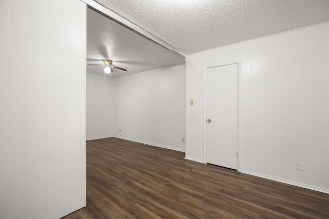 empty room featuring a textured ceiling, dark hardwood / wood-style floors, and ceiling fan