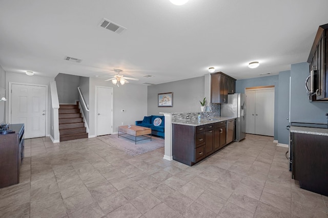 kitchen with ceiling fan, sink, decorative backsplash, dark brown cabinets, and appliances with stainless steel finishes