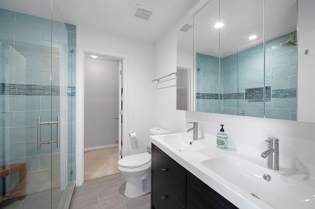 bathroom featuring tile patterned floors, a shower with door, vanity, and toilet