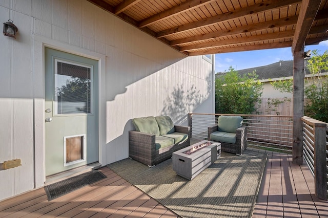 wooden terrace featuring an outdoor living space with a fire pit