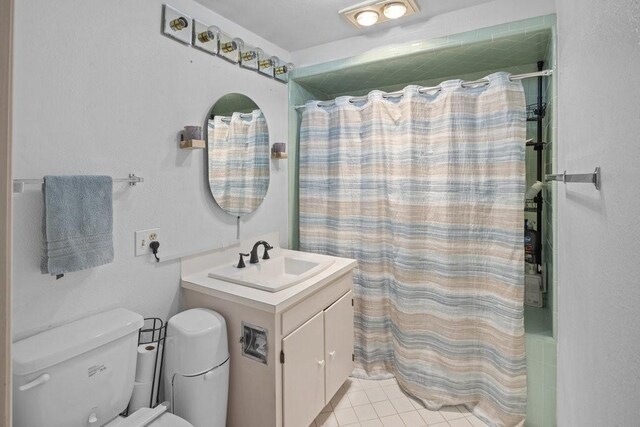 bathroom with curtained shower, tile patterned flooring, vanity, and toilet