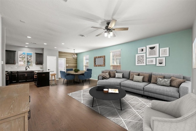 living room featuring ceiling fan, sink, and light hardwood / wood-style flooring