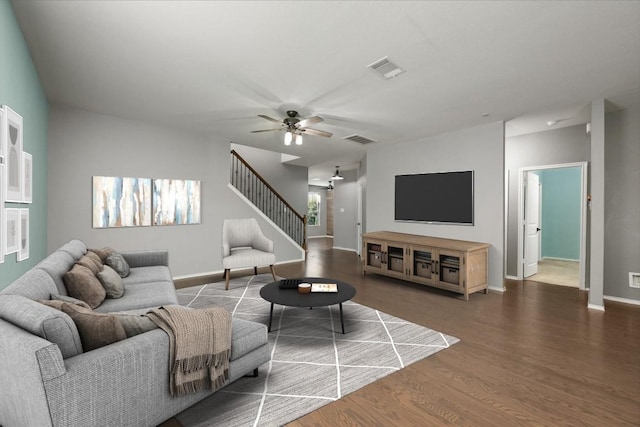 living room featuring ceiling fan and dark wood-type flooring