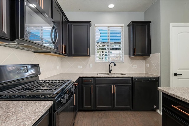 kitchen featuring backsplash, dark wood-type flooring, sink, and black appliances