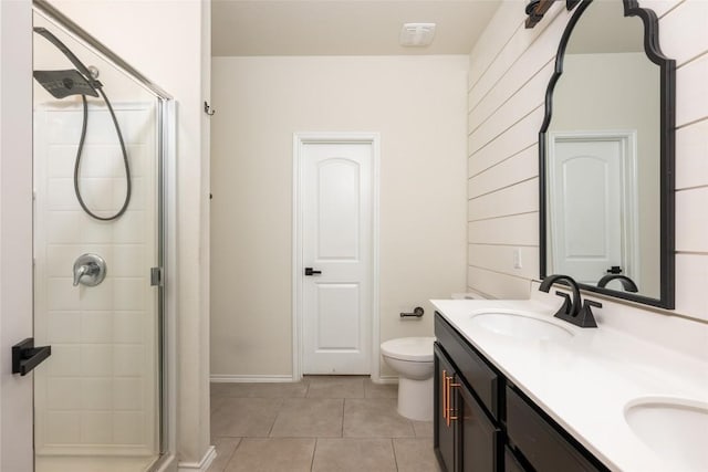 bathroom featuring tile patterned flooring, vanity, a shower with shower door, and toilet