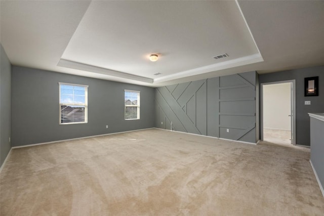 carpeted empty room with a tray ceiling