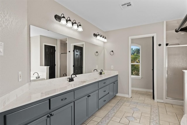 bathroom featuring tile patterned floors, a shower with door, and vanity