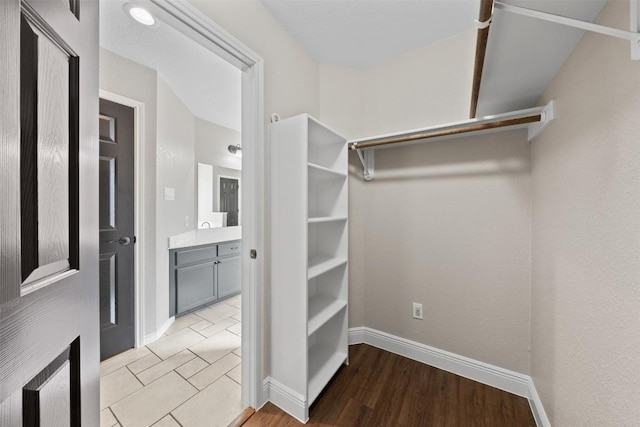 walk in closet with light hardwood / wood-style floors