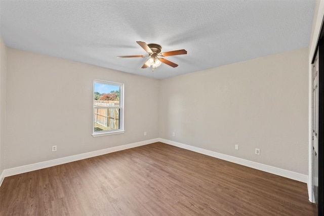 spare room with a textured ceiling, dark hardwood / wood-style flooring, and ceiling fan