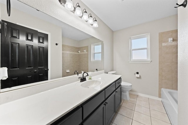 full bathroom with tile patterned floors, tiled shower / bath, vanity, and toilet