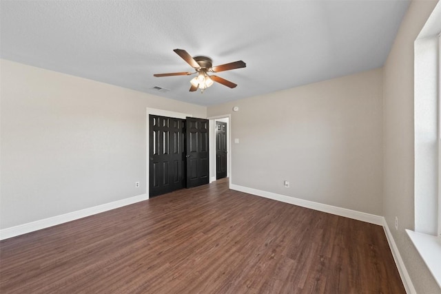 unfurnished bedroom featuring a textured ceiling, dark hardwood / wood-style flooring, and ceiling fan