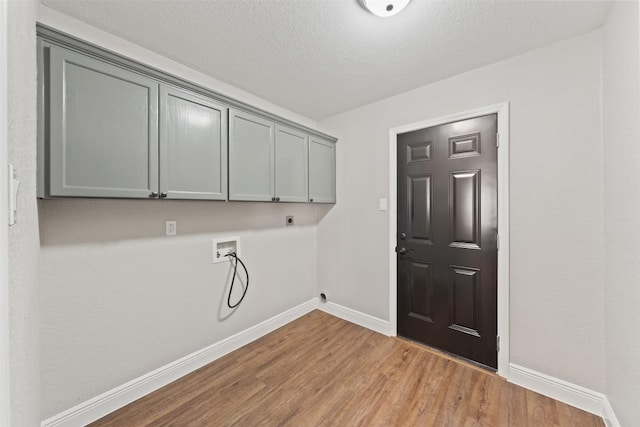 laundry area featuring washer hookup, cabinets, hookup for an electric dryer, light hardwood / wood-style floors, and a textured ceiling