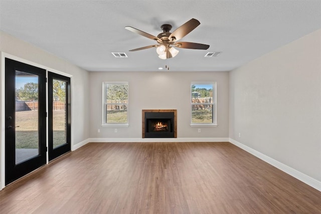 unfurnished living room featuring hardwood / wood-style floors, french doors, and ceiling fan