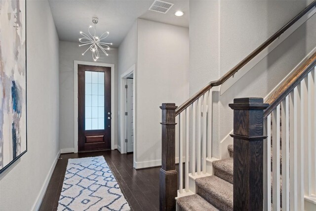 entryway with dark hardwood / wood-style flooring and a notable chandelier