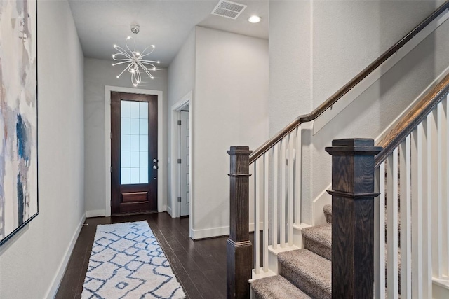 entryway featuring baseboards, visible vents, dark wood-type flooring, stairs, and a notable chandelier