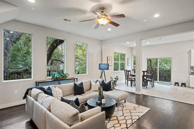 living room with dark wood-type flooring and ceiling fan