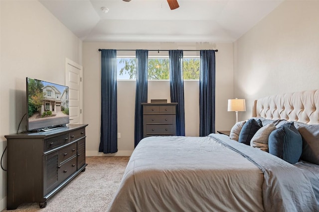 carpeted bedroom featuring vaulted ceiling, ceiling fan, and a tray ceiling