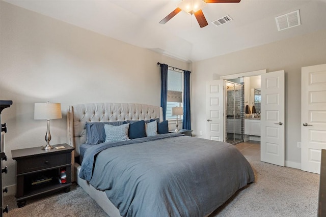 bedroom with ceiling fan, ensuite bath, and carpet flooring