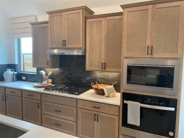 kitchen with stainless steel appliances and tasteful backsplash