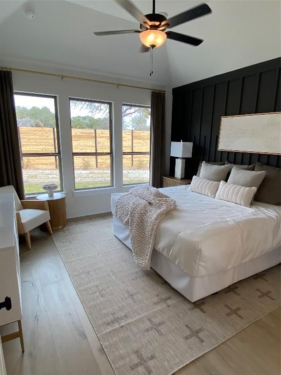 bedroom featuring vaulted ceiling, light hardwood / wood-style flooring, and ceiling fan