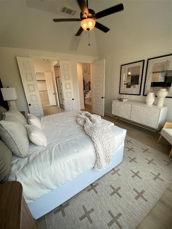 bedroom with a walk in closet, ceiling fan, a closet, and hardwood / wood-style flooring