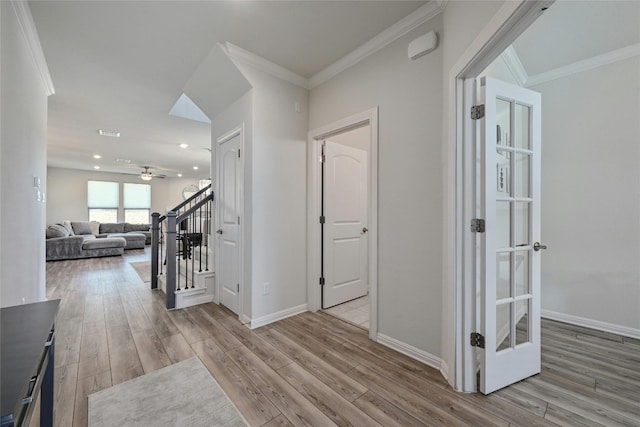 hallway featuring ornamental molding and light wood-type flooring