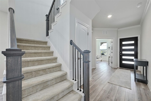 entrance foyer with crown molding and wood-type flooring