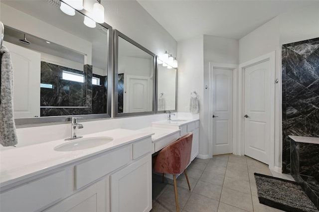 bathroom featuring tile patterned floors, vanity, and a tile shower