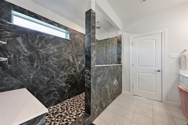 bathroom with a tile shower and tile patterned floors